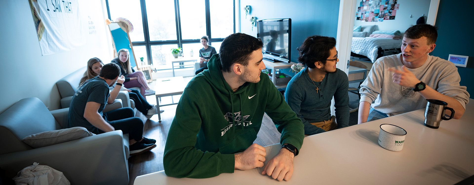 Group of students talking in Aspire Hall apartment